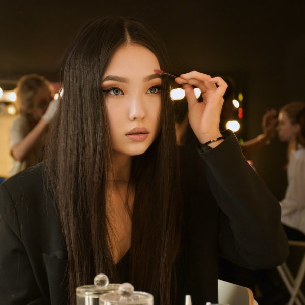 woman in black long sleeve shirt holding her hair